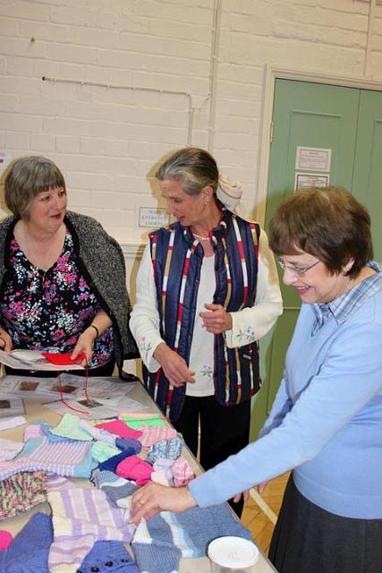 Julie, Liz - Janice discuss the Knit for Peace jumpers    knitted by members.jpg